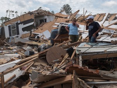 A couple react as they go through their destroyed mobile home following the passing of hurricane Laura in Lake Charles, Louisiana, on August 27, 2020. - Hurricane Laura tore off roofs and shredded buildings in the southern US state of Louisiana as it slammed into the coast early on August 27 killing at least one person, with shaken residents emerging to survey the damage. Forecasters warned of the continued risk of a storm surge as the hurricane -- one of the strongest to ever hit the region -- moved inland and weakened rapidly. (Photo by ANDREW CABALLERO-REYNOLDS / AFP) (Photo by ANDREW CABALLERO-REYNOLDS/AFP via Getty Images)