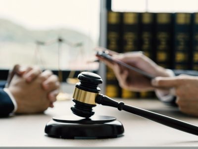 gavel hammer, Lawyer hand holding pen and providing legal consult business dispute service to the man at the office with justice scale.
