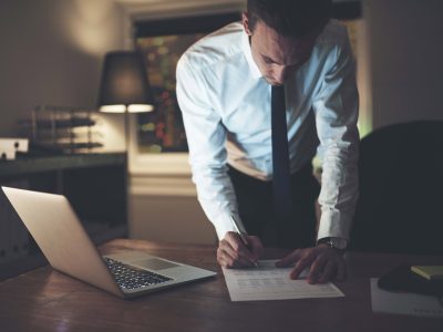 Lawyer signing document at night at office, working overtime